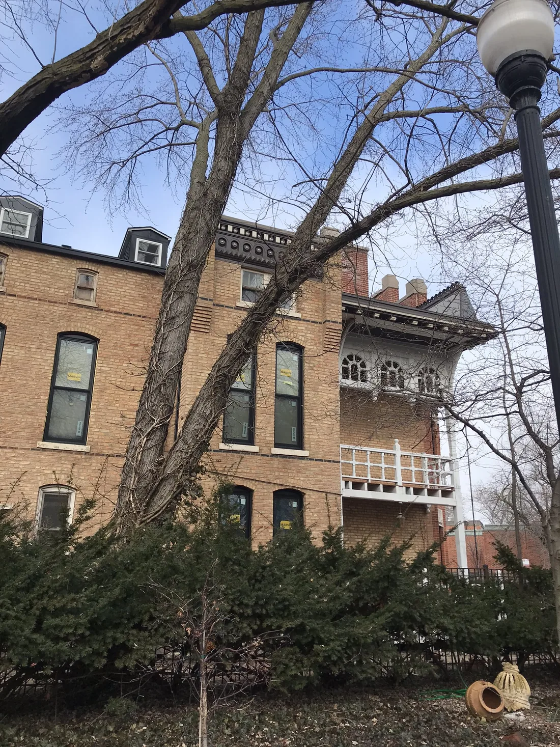2114 N. Lincoln Avenue: a brick building with segmental-arched windows, seen through bare branches