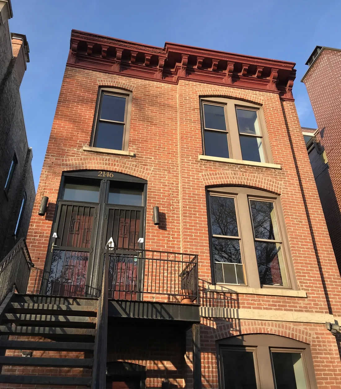2146 N. Magnolia Avenue: a red brick two-flat with a bracketed cornice, stone lintels and an iron stoop rail