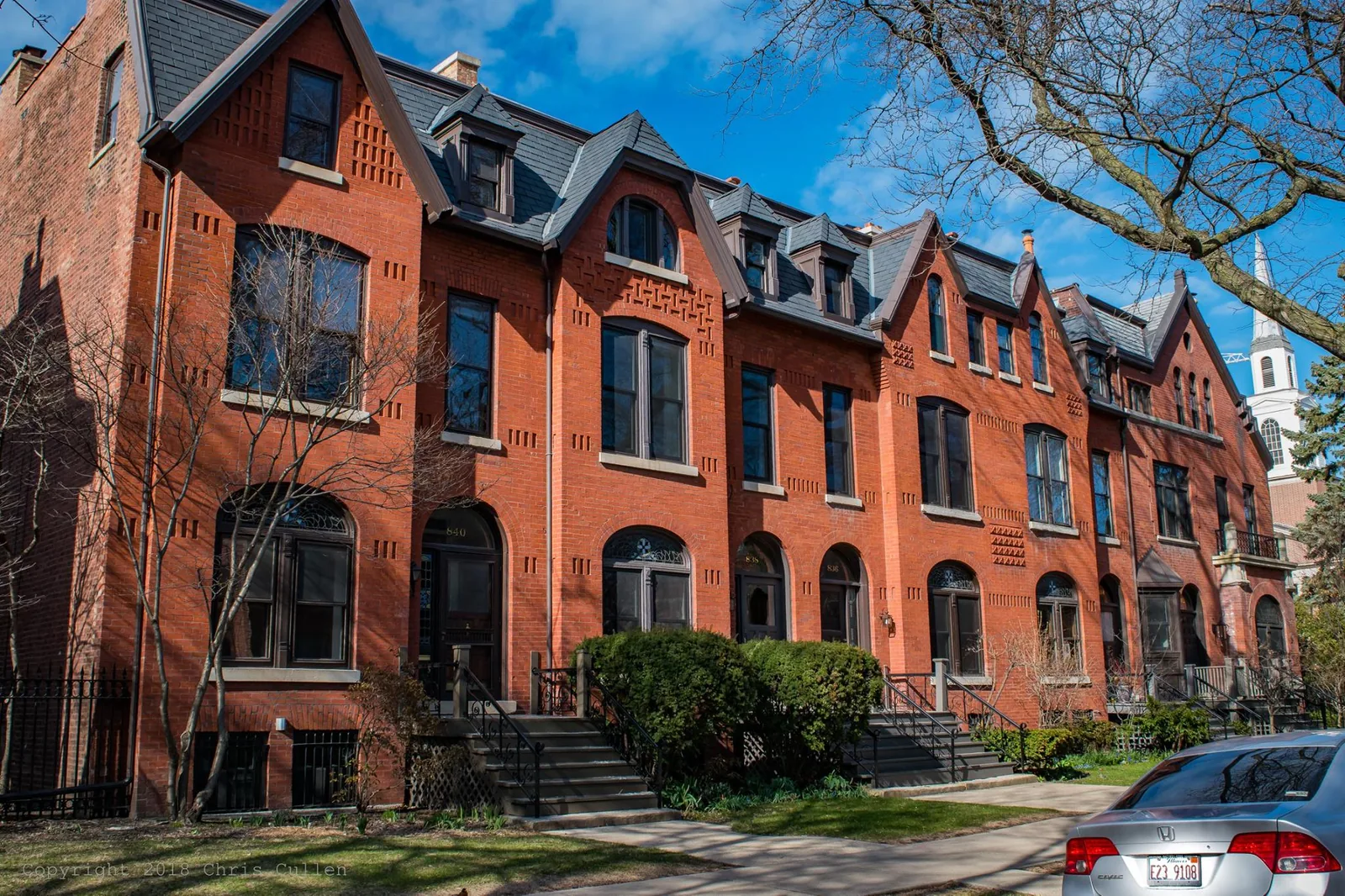 The McCormick rowhouses on Belden Avenue in Lincoln Park, a red brick terrace with dormers and arched doorways